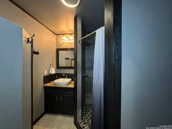 a bathroom with a granite countertop sink and mirror