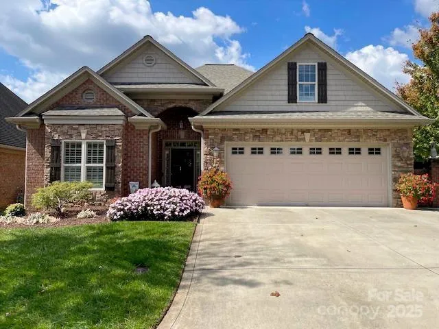 a front view of a house with a garden and yard