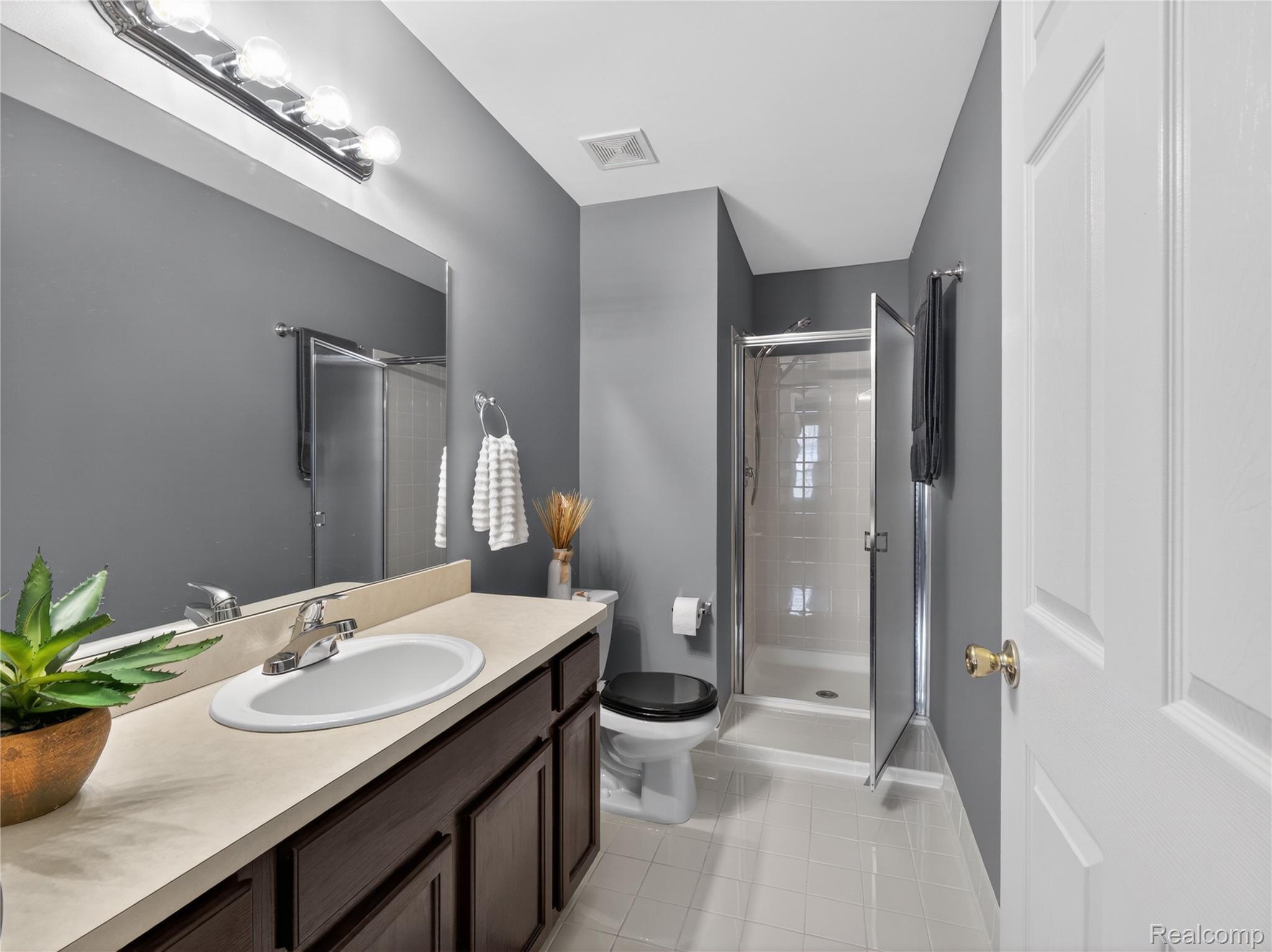 1834 Flagstone Circle, Unit 37 Rochester, MI 48307 - Photo 21 of 31 Full bath with a stall shower, vanity, and light tile patterned floors
