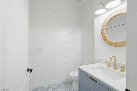 a bathroom with a sink a toilet and mirror