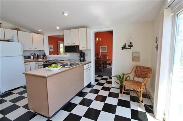 89 Shore Road Harwich, MA 02671 - Photo 11 of 20 a kitchen with a checkered floor and white cabinets
