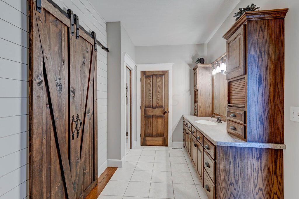 4045 Russell Road Mount Gilead, OH 43338 - Photo 26 of 74 • Ceramic tile flooring • Gray painted walls • Two walk-in closets • Body jet shower (plumbed for tub) • Amish custom cabinets • Lots of storage • Toilet room