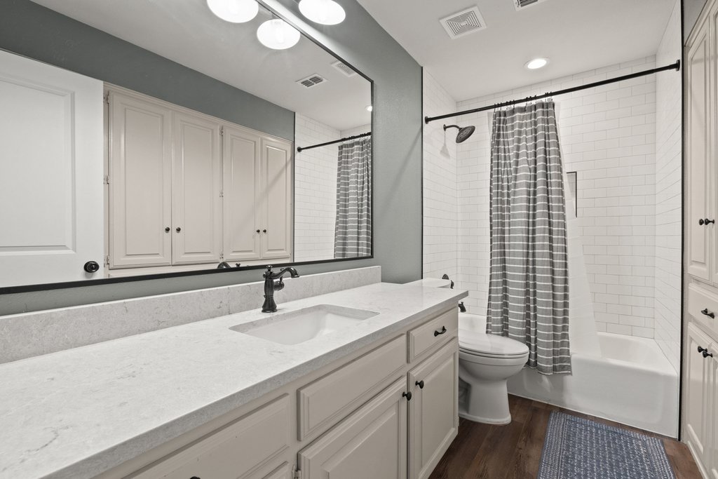 23644 Nameless Road Leander, TX 78641 - Photo 14 of 40 A well-appointed bathroom features a single vanity, a combination tub and shower, and warm hardwood flooring.