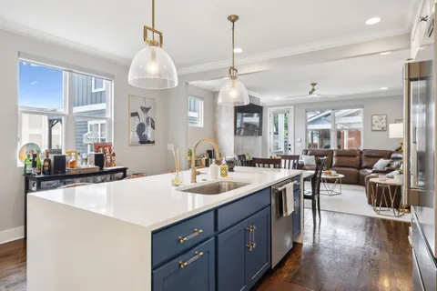 a kitchen with a sink a counter space appliances and cabinets