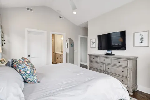 a bedroom with a bed and a flat screen tv in white dresser