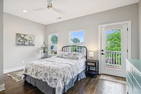 a bedroom with a bed a painting on the wall and a large window