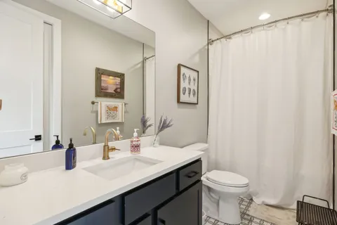 a bathroom with a sink vanity mirror and toilet