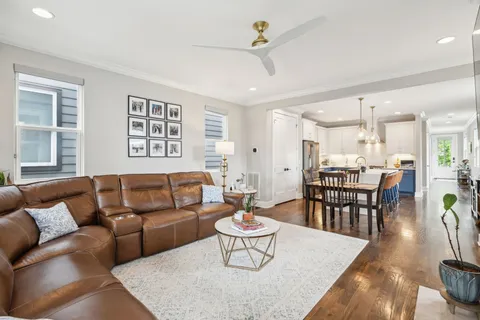 a view of a dining room with furniture a rug and wooden floor