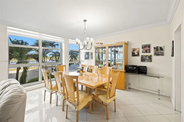 a view of a dining room with furniture large windows and a chandelier