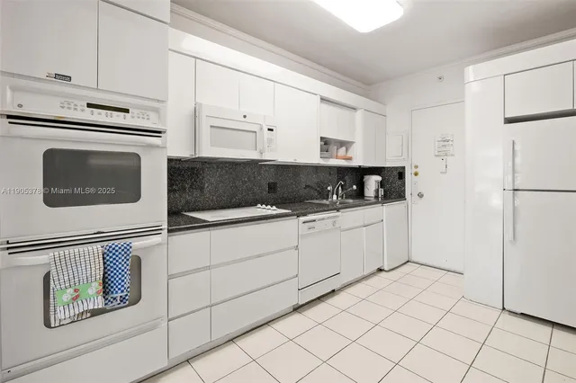 a kitchen with white cabinets and white appliances
