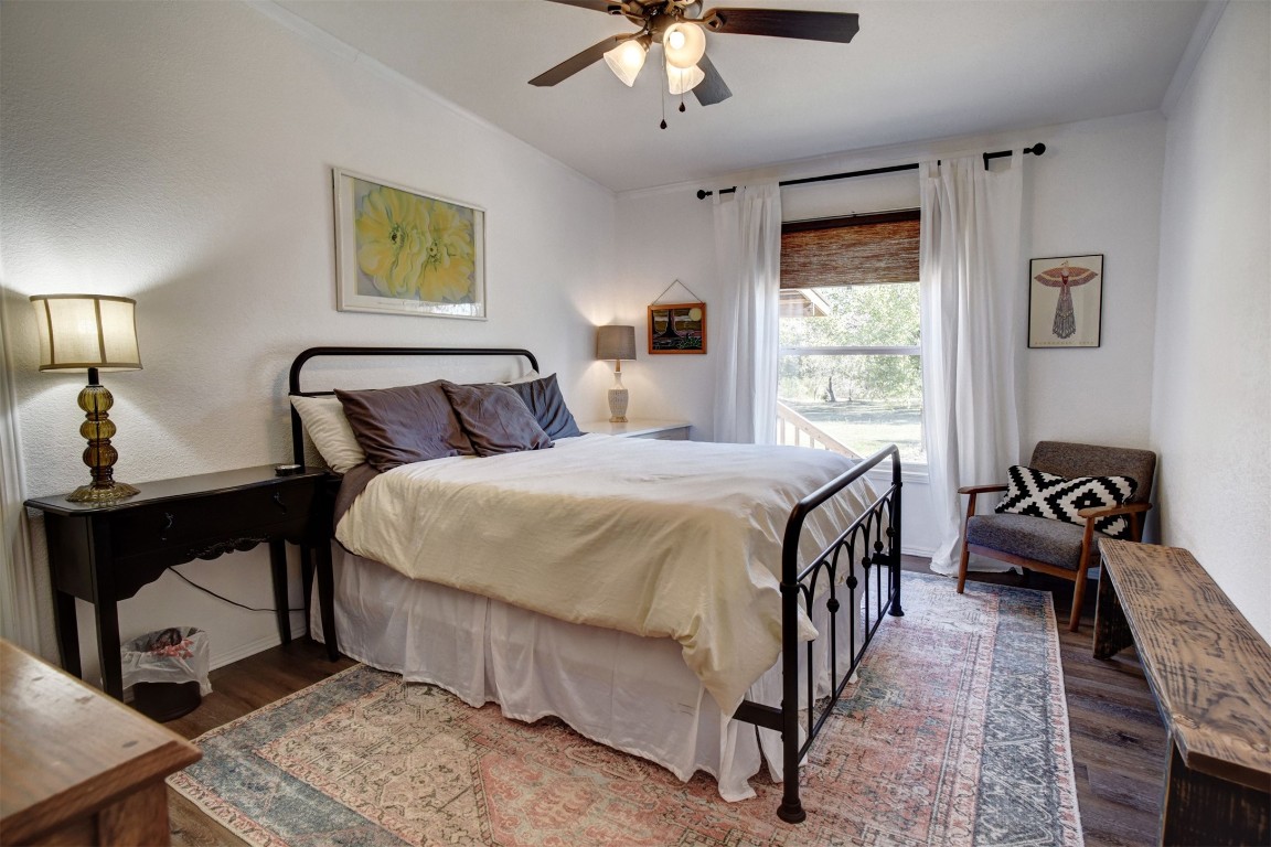 421 Krchnak Road Smithville, TX 78957 - Photo 22 of 40 a bedroom with a bed and a chandelier