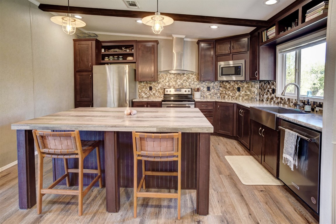 421 Krchnak Road Smithville, TX 78957 - Photo 7 of 40 a kitchen with stainless steel appliances granite countertop a table chairs sink and cabinets