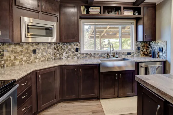 a kitchen with stainless steel appliances granite countertop a refrigerator stove and sink