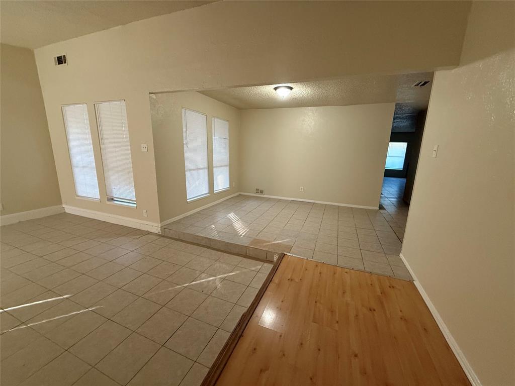 5005 Galaxie Road Garland, TX 75044 - Photo 7 of 8 an empty room with wooden floor and windows