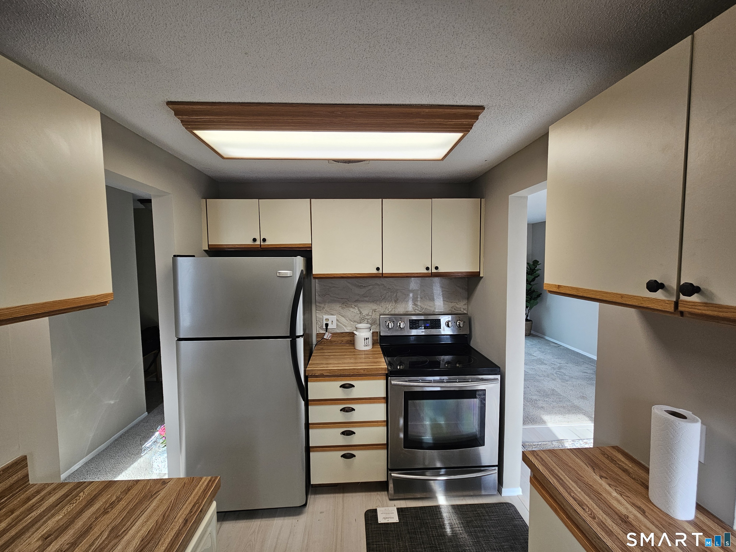 91 Trolley Crossing Lane, Unit 91 Middletown, CT 06457 - Photo 9 of 29 a kitchen with a refrigerator and a stove top oven