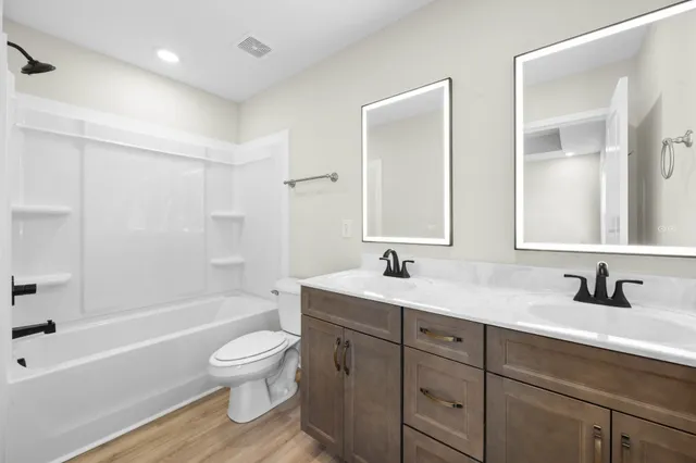 a bathroom with a toilet a sink a bathtub and a mirror