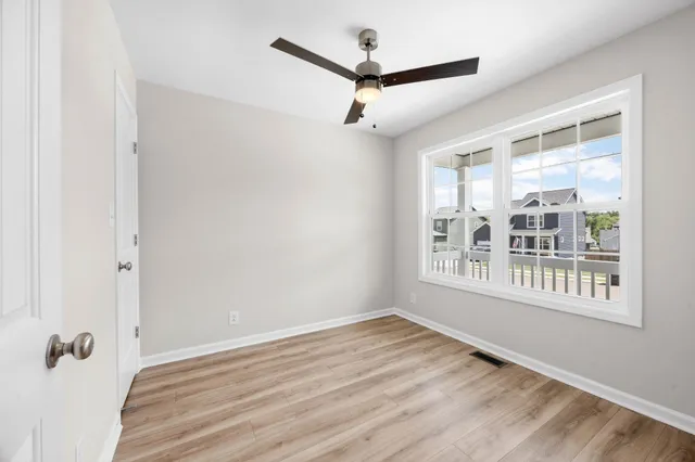a view of a big room with wooden floor and windows