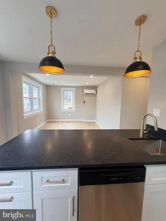 a view of kitchen island a sink a refrigerator and stove
