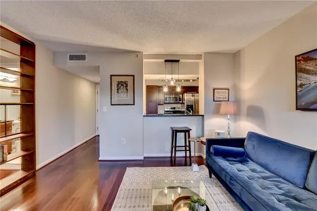 a living room with furniture and a wooden floor