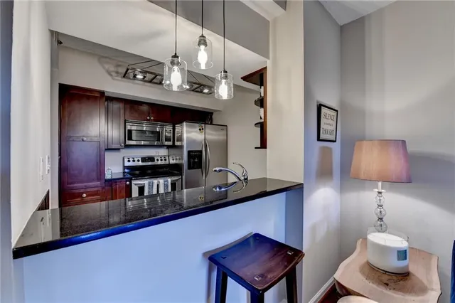 a kitchen with stainless steel appliances granite countertop a sink a stove and a refrigerator