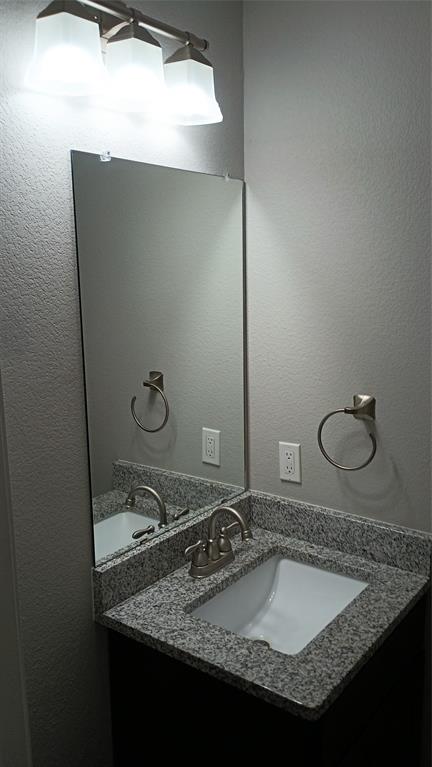 2004 Pecan Street, Unit G Commerce, TX 75428 - Photo 3 of 10 Bathroom featuring a textured wall and vanity