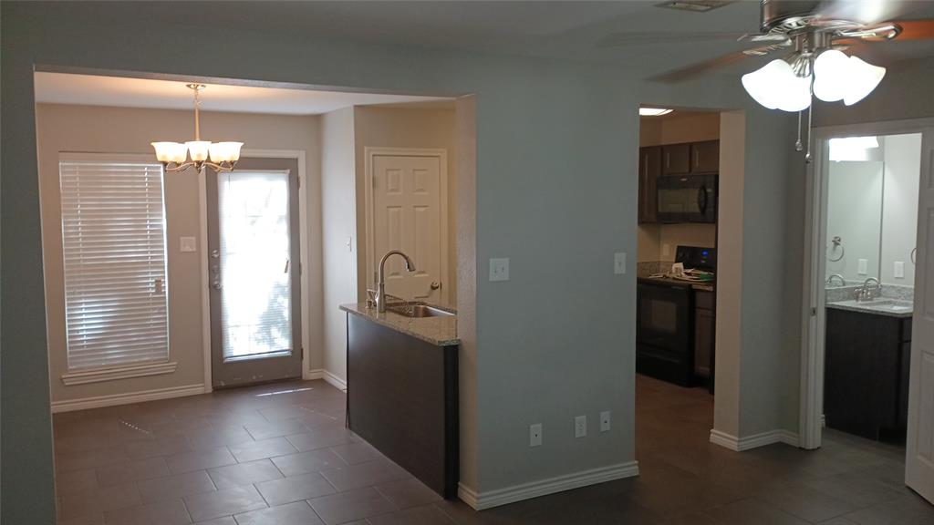 2004 Pecan Street, Unit G Commerce, TX 75428 - Photo 4 of 10 Kitchen with black appliances, dark tile patterned floors, ceiling fan