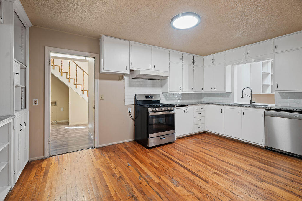 3514 25th Street Lubbock, TX 79410 - Photo 1 of 27 a kitchen with stainless steel appliances granite countertop a refrigerator a sink dishwasher a stove with cabinets and wooden floor