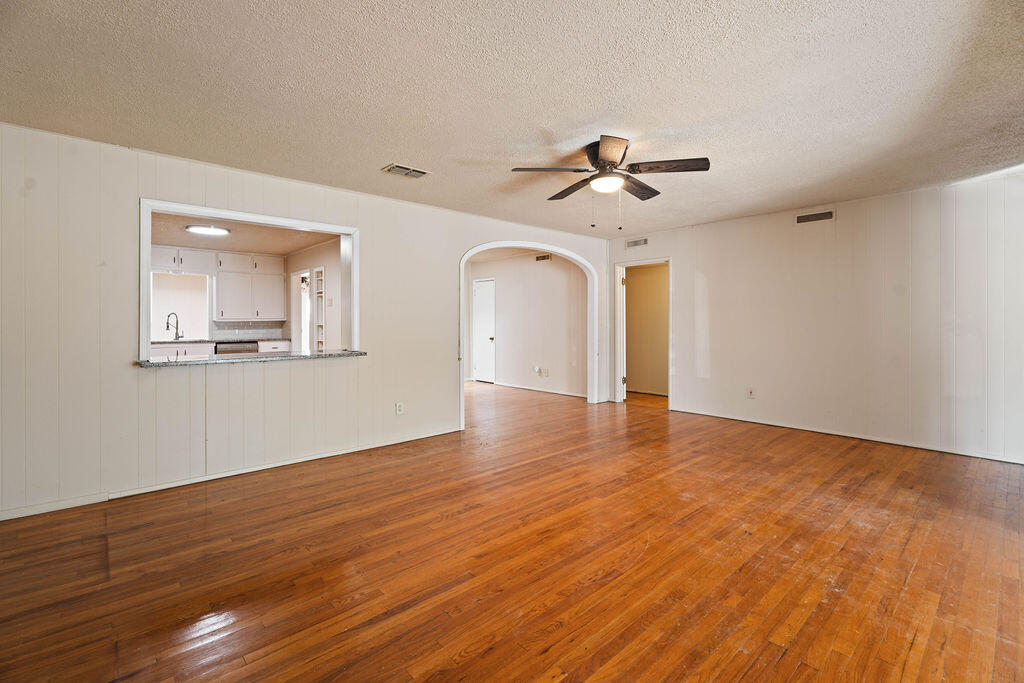 3514 25th Street Lubbock, TX 79410 - Photo 6 of 27 a view of an empty room with wooden floor and a ceiling fan