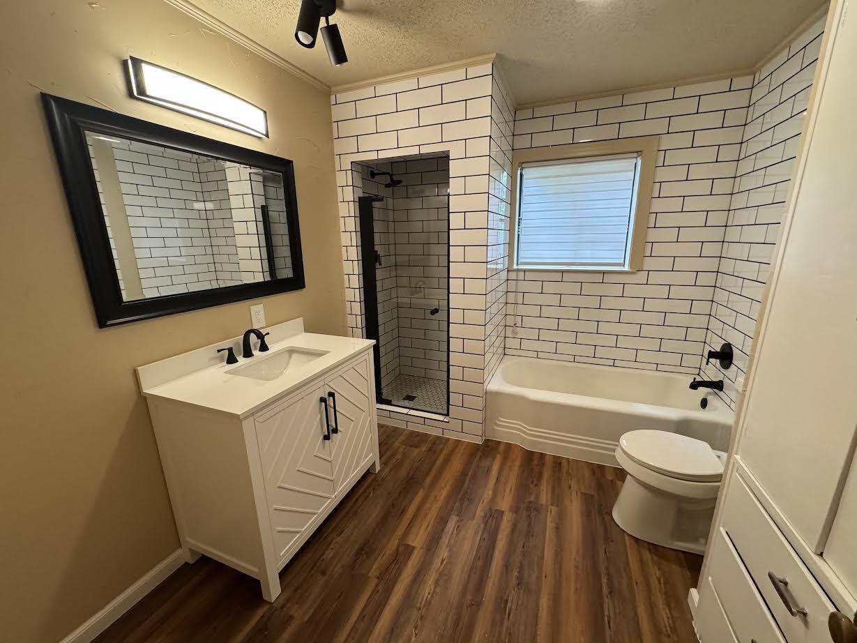 3514 25th Street Lubbock, TX 79410 - Photo 8 of 27 a bathroom with a granite countertop sink toilet and shower