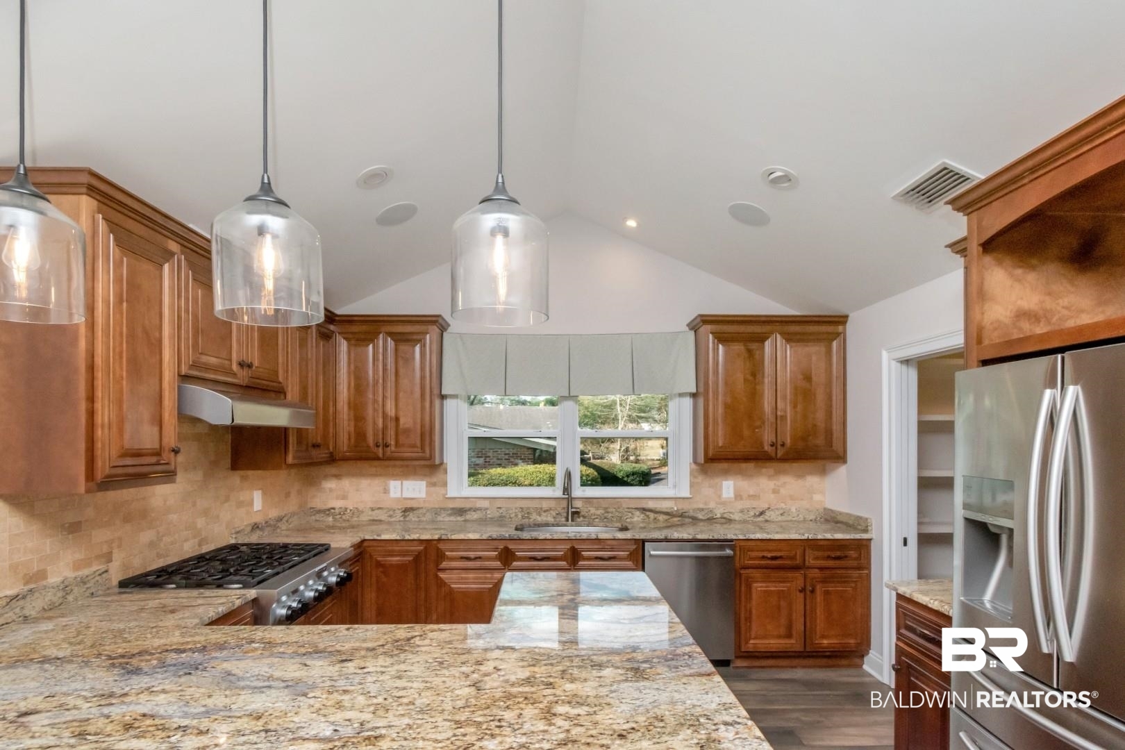 231 Rochester Road Mobile, AL 36608 - Photo 11 of 51 Kitchen with wood finish cabinetry, light stone counters, lofted ceiling, stainless steel appliances, and tasteful backsplash