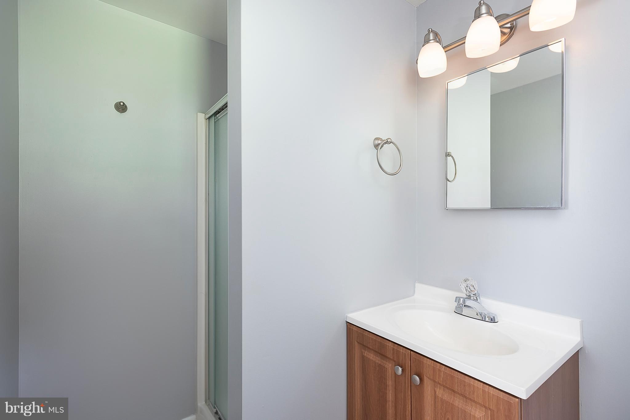 1316 Gatefield Road Baltimore, MD 21228 - Photo 23 of 30 a bathroom with a sink vanity and a mirror