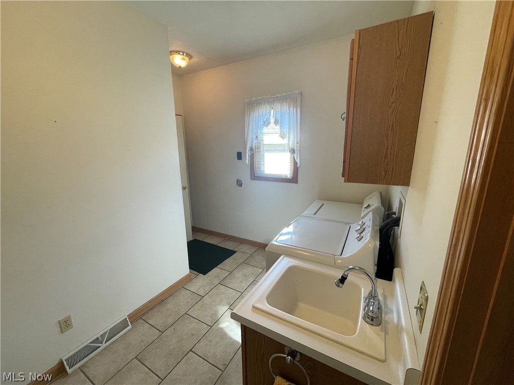 185 Mathews Road Youngstown, OH 44512 - Photo 16 of 29 Washroom featuring cabinets, sink, light tile floors, and washing machine and clothes dryer