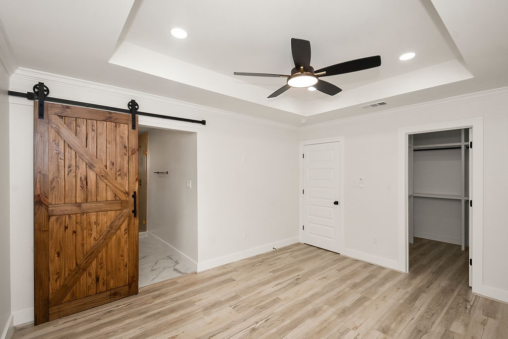6106 Rutherglenn Drive Houston, TX 77096 - Photo 20 of 41 Another view of the beautifully updated primary suite showcasing tray ceilings and modern barn door accents.