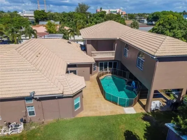 an aerial view of a house with swimming pool and garden view