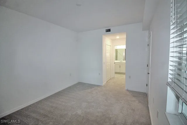 a view of an empty room with a fireplace and a window