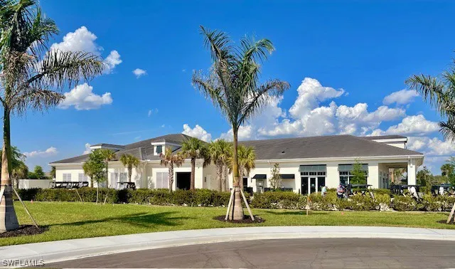 a front view of a building with garden and trees