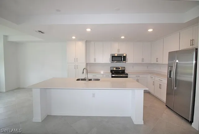a kitchen with stainless steel appliances a refrigerator sink and microwave