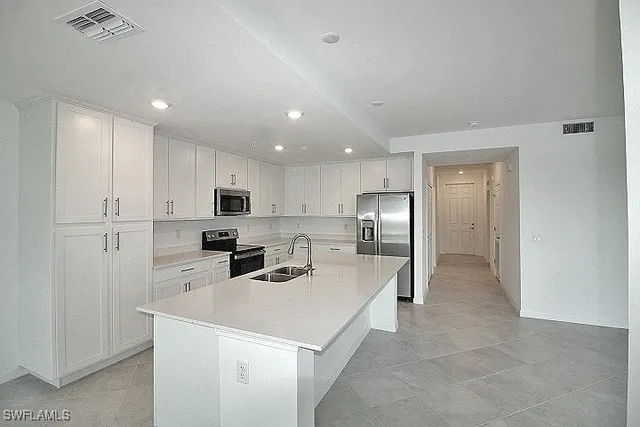 a kitchen with stainless steel appliances a refrigerator sink and microwave