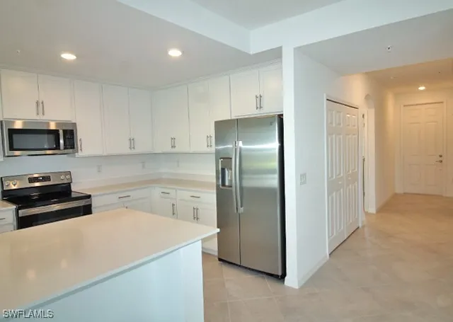 a kitchen with a refrigerator sink and cabinets