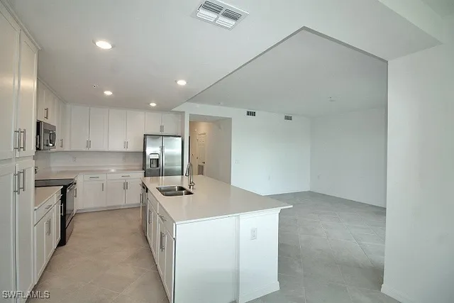 a kitchen with a sink window and stainless steel appliances
