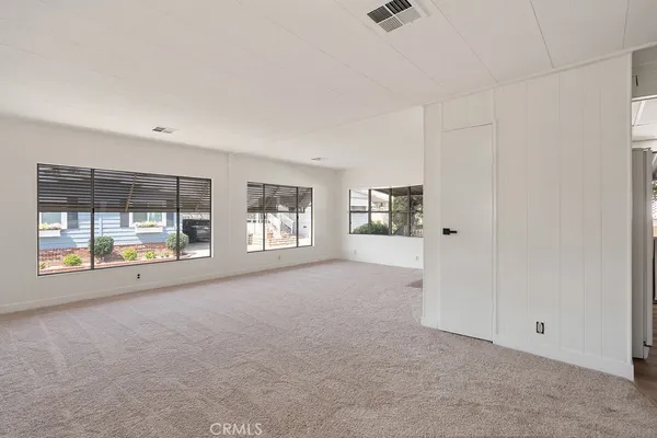 a big room with windows and chandelier fan