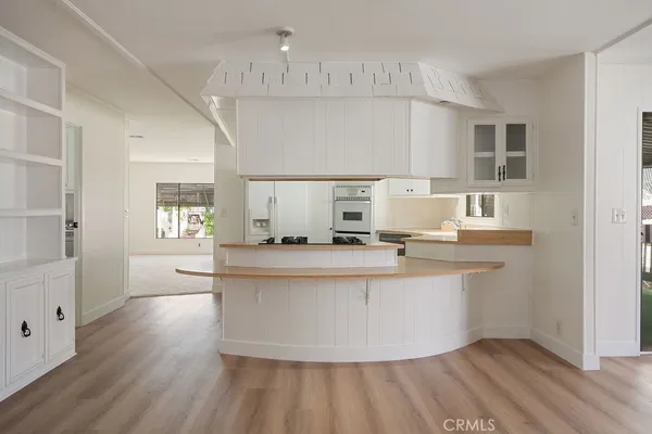 a large white kitchen with kitchen island a sink appliances and a cabinets