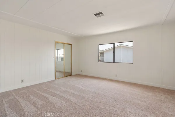 an empty room with windows and closet