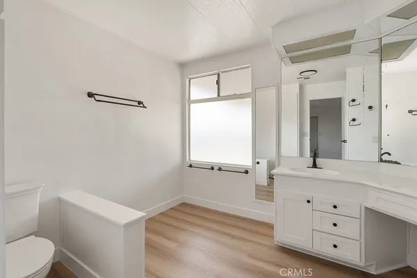 a bathroom with a sink a toilet a vanity and mirror