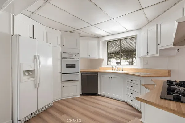 a kitchen with granite countertop white cabinets and stainless steel appliances