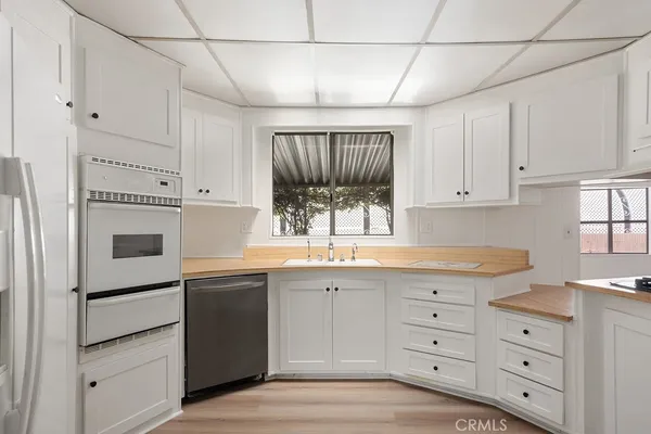 a kitchen with granite countertop white cabinets and white appliances