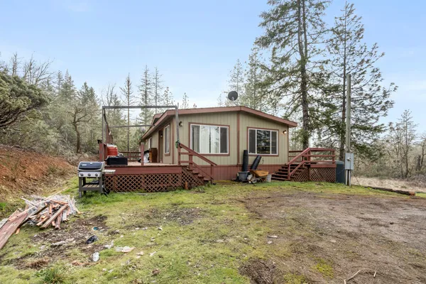 a view of a house with a yard and sitting area