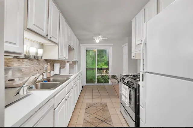 a kitchen with granite countertop a sink a counter top space and cabinets