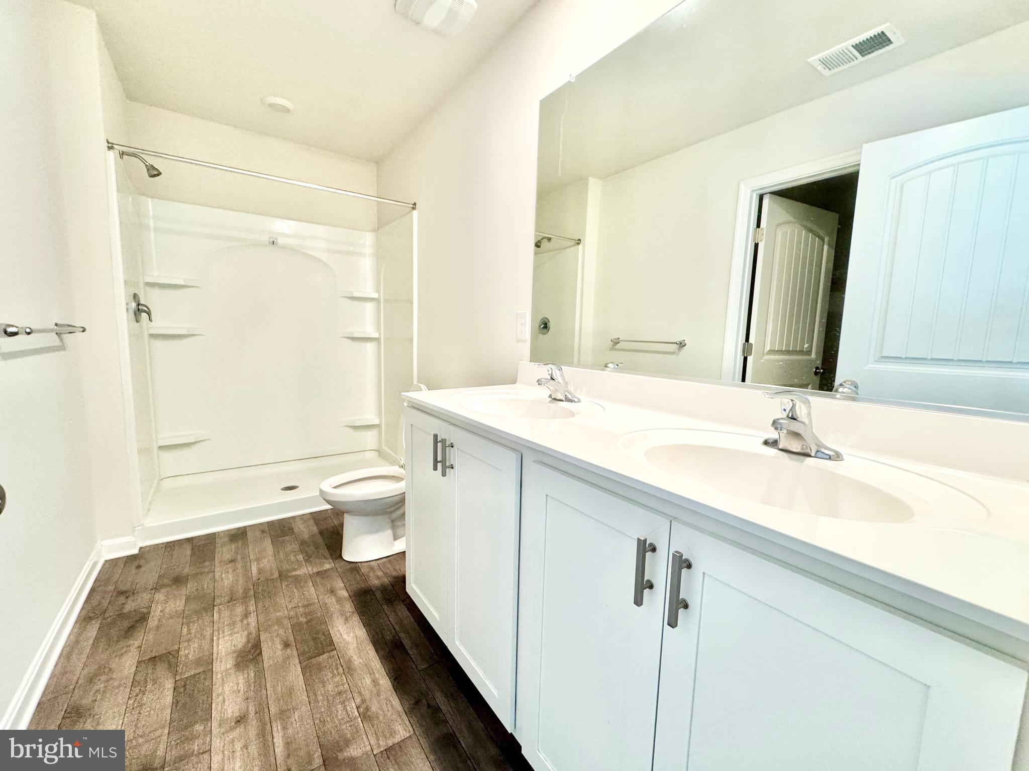 198 Currant Circle Magnolia, DE 19962 - Photo 15 of 19 a spacious bathroom with a double vanity sink toilet mirror and shower