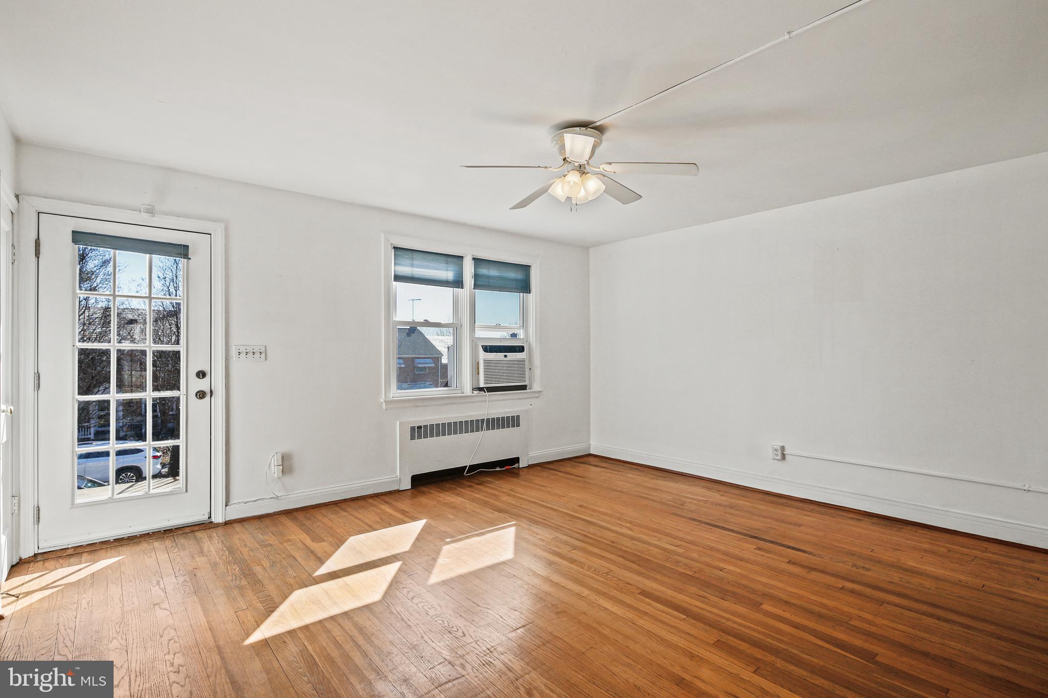3812 Rexmere Road Baltimore, MD 21218 - Photo 3 of 35 a view of an empty room with a window and wooden floor